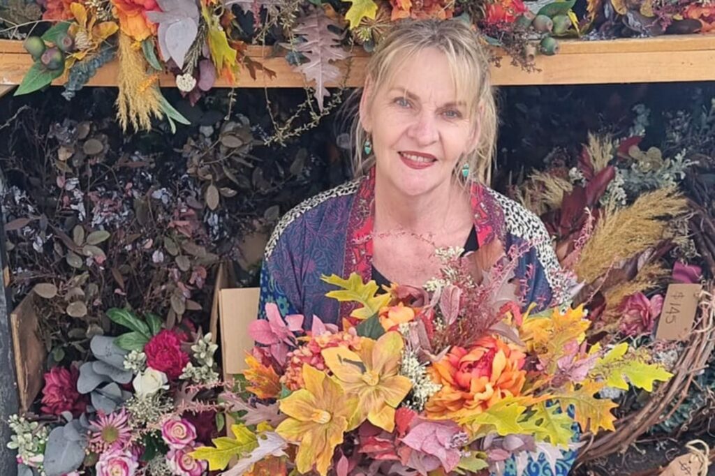 Jane Flowergirl Florist sitting in front of a market load of bouquets